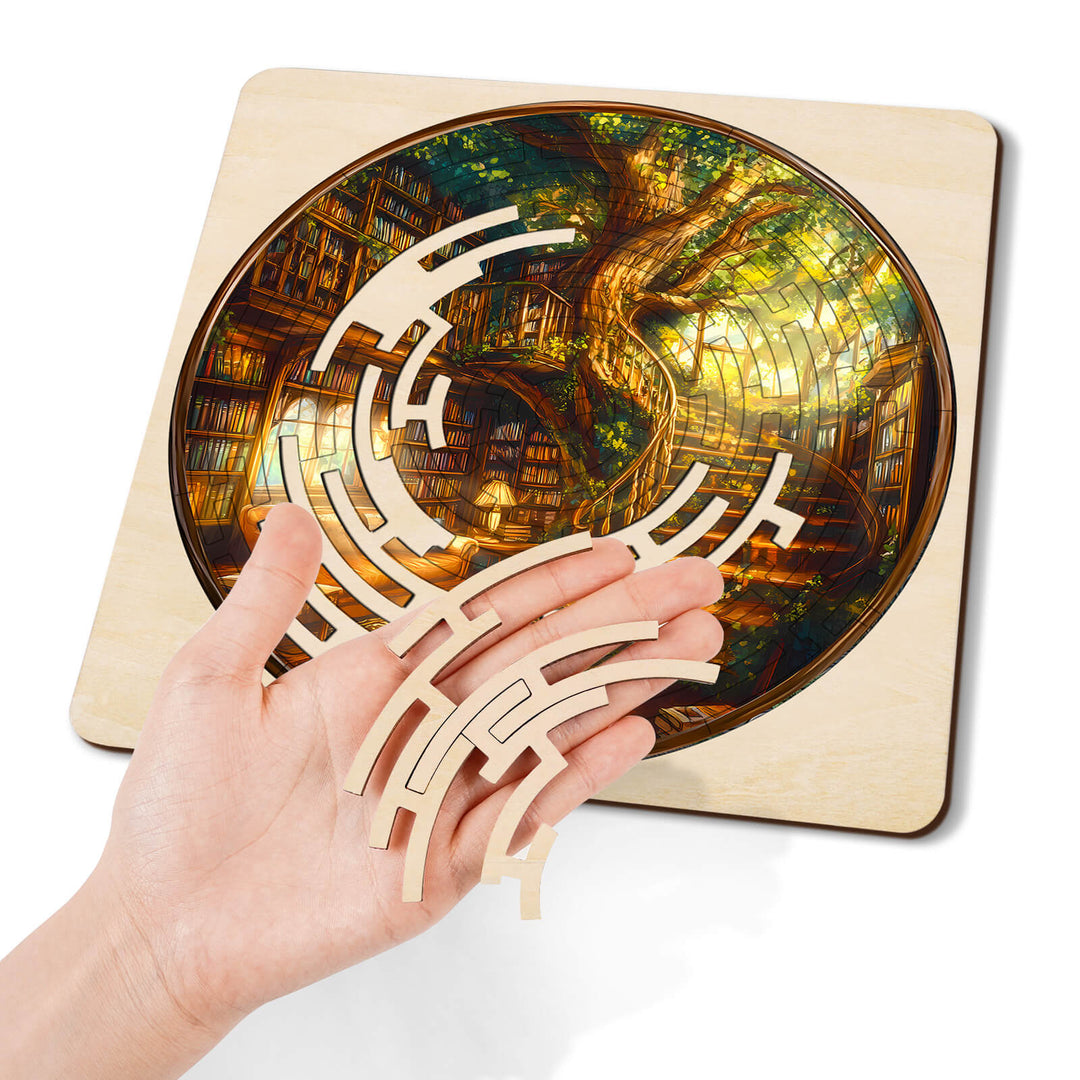 Person holding maze pieces over a beautiful jigsaw puzzle of a tree library, showcasing focus and creativity.