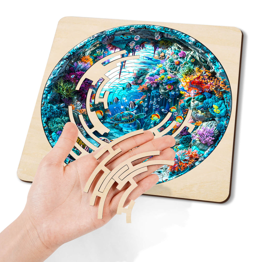 Hand holding maze pieces above a colorful blue ocean jigsaw puzzle, promoting focus and brain engagement.
